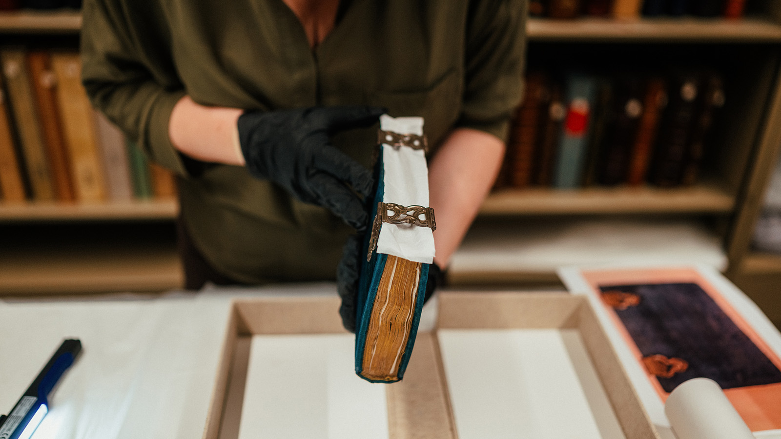 Conservadora Ana Maria Campino durante o processo de verificação do estado de conservação de um manuscrito iluminado europeu.