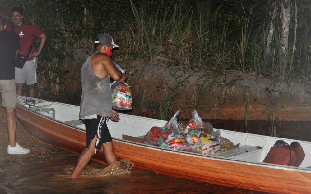 Members of the campaign fill a boat with baskets to offer to the Tururukari Kambeba community. © SOS Amazonia